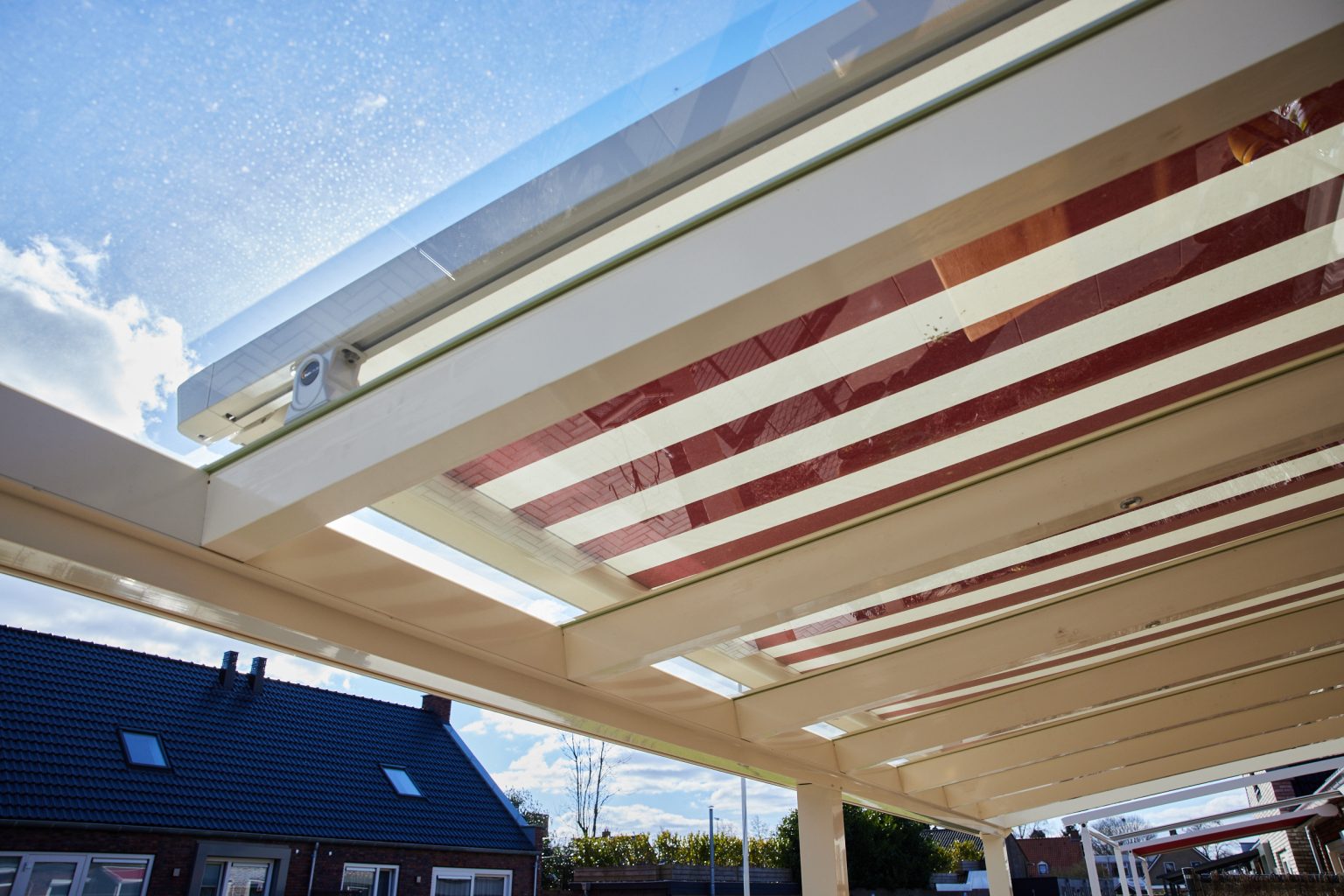 Crèmewitte veranda met glazen dak en zonwering