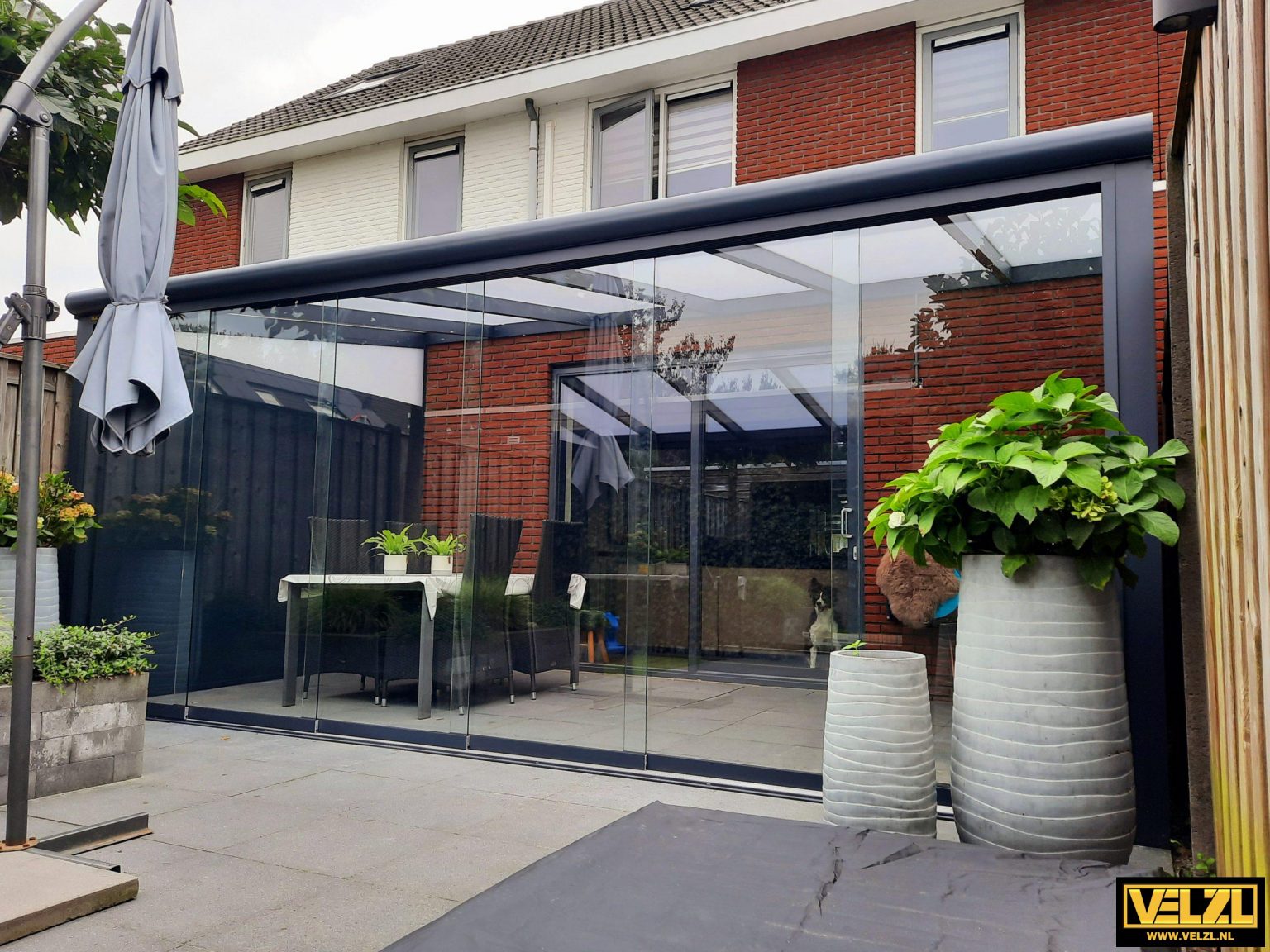 Uitzicht vanuit een tuinkamer door glazen schuifwanden