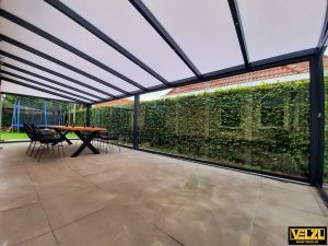 Grote antraciet kleurige tuinkamer met polycarbonaat dak van binnenuit gezien