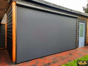 Zwart screen met een grote overspanning geplaatst in een bestaande overkapping
