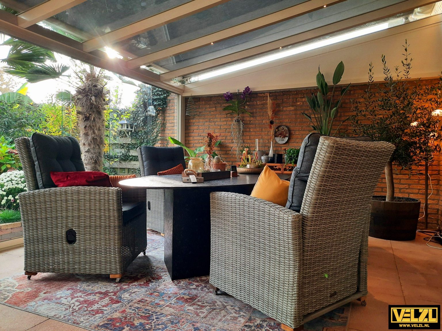 Gezellig ingerichte tuinkamer met zonwering op het glazen dak