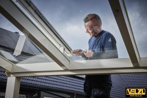 Monteur van VELZL Coevorden achter glazen dak veranda