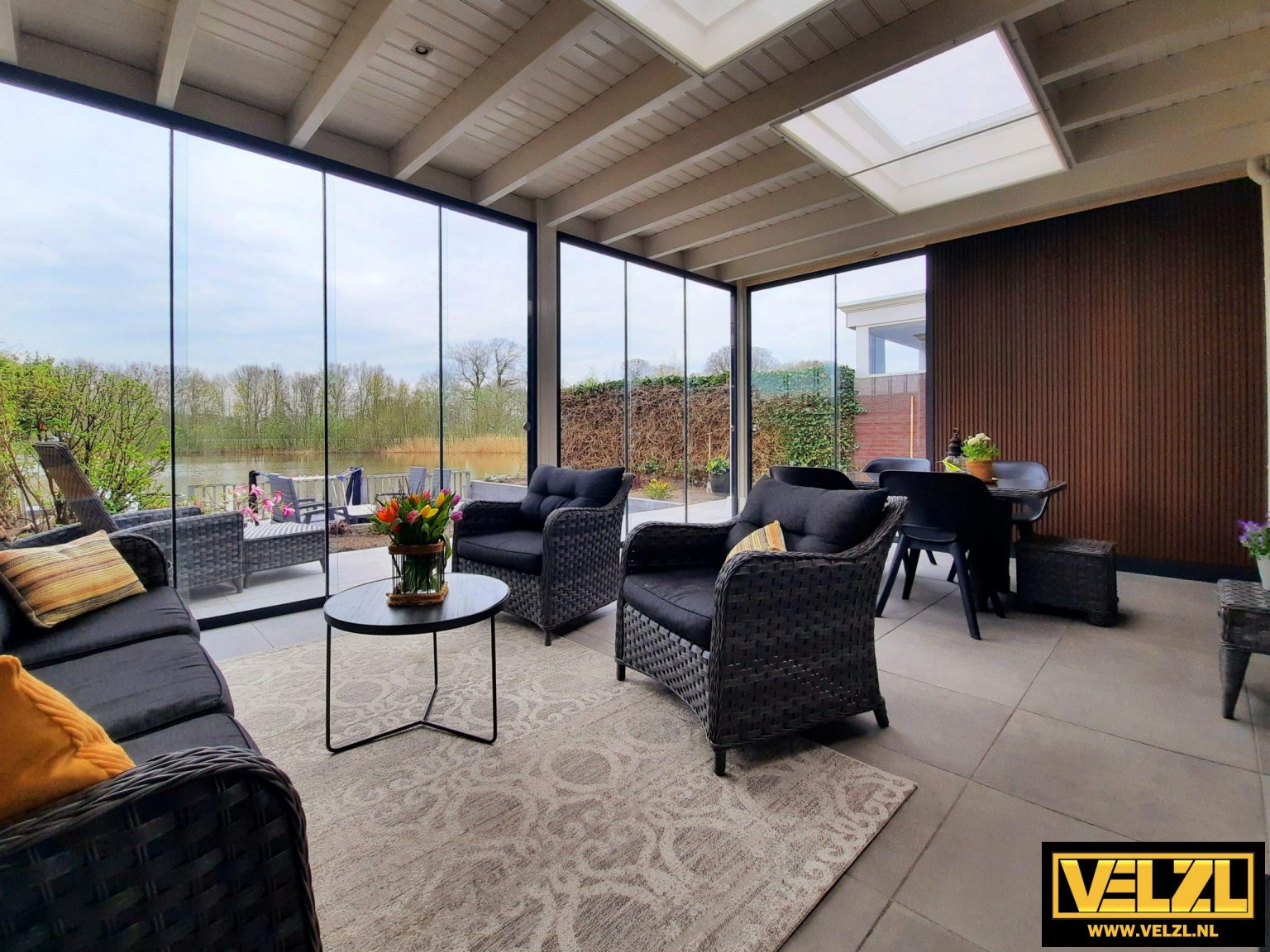 Tuinkamer met glazen schuifwanden en loungeset