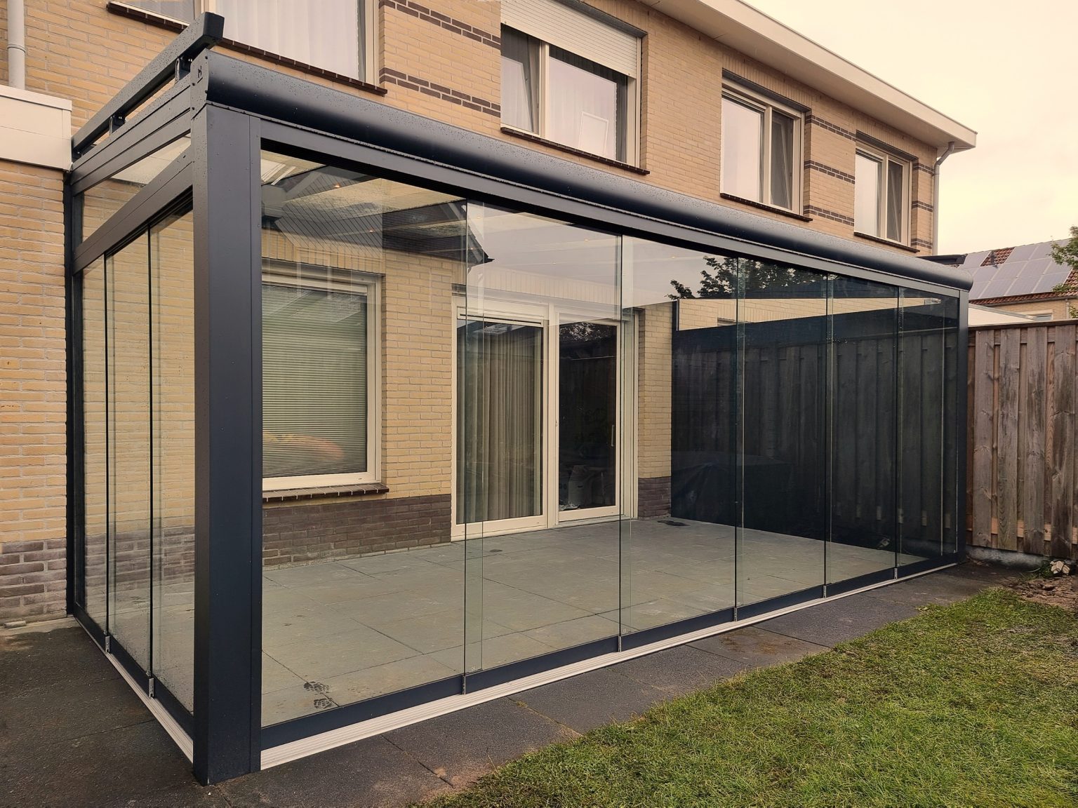 Tuinkamer met glazen schuifwanden aan een woning