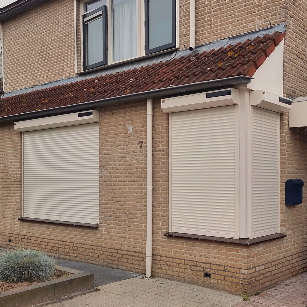 Crème rolluiken aan een rijwoning