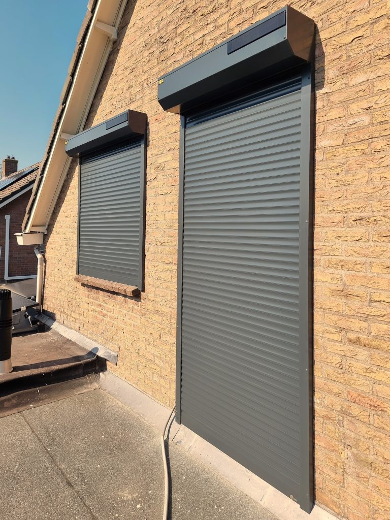 Rolluiken aan een woning met gele gevelsteen