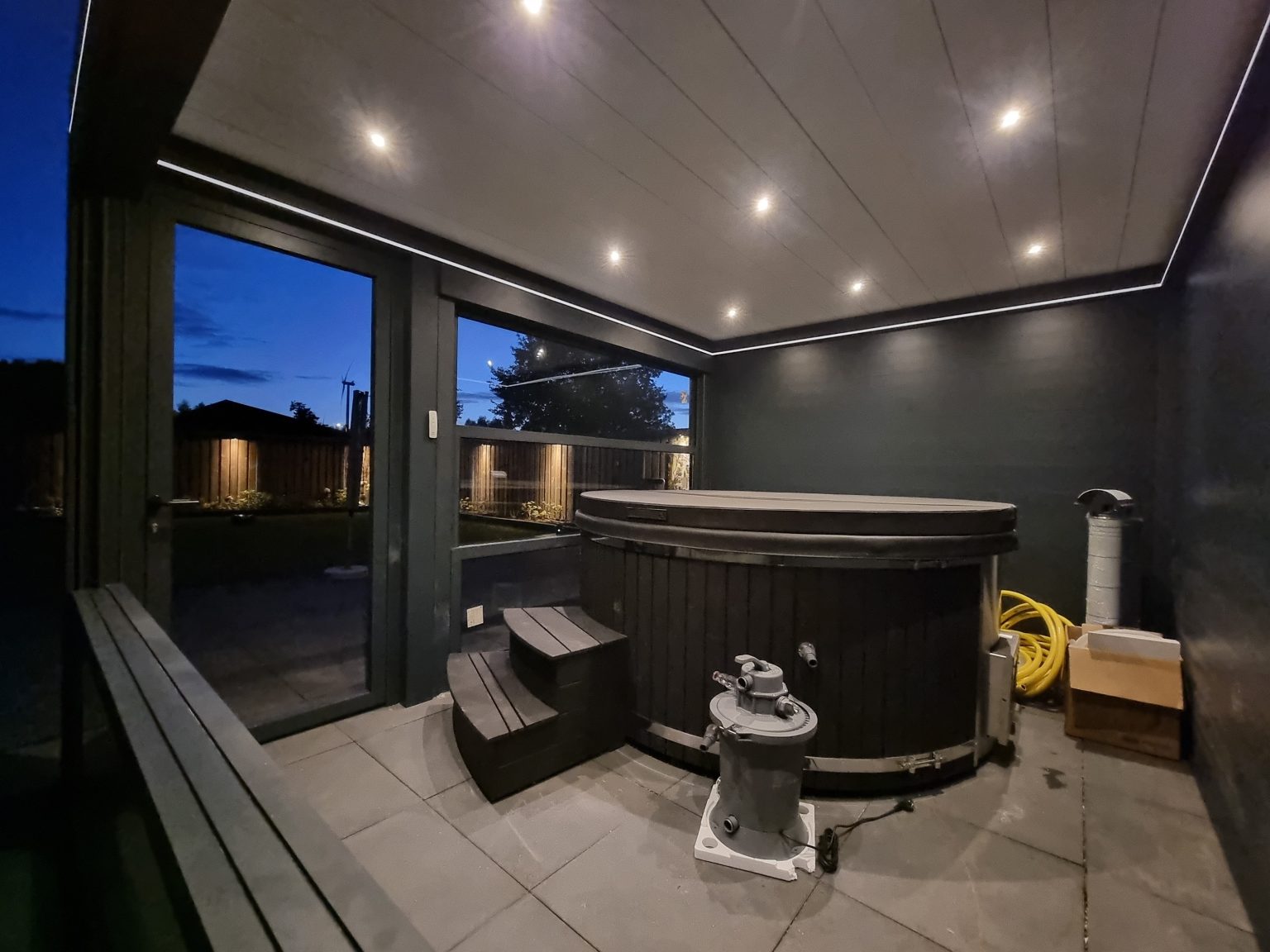 Hottub onder een lamellendak met glazen wanden