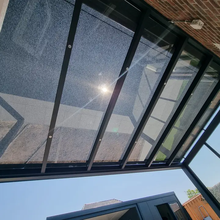 Verandazonwering boven een glazen dak, van binnen gezien