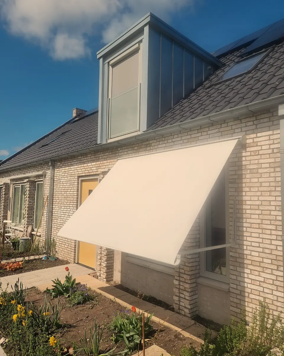 Crèmekleurig uitvalscherm boven een raam van een rijwoning, geplaatst door VELZL