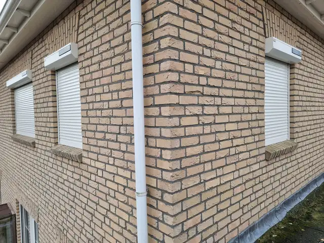 Witte rolluiken aan een gevel, geplaatst door VELZL