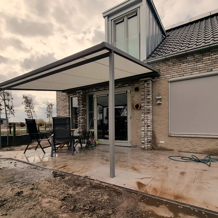 Pergola-zonwering naast een woning met dakkapel