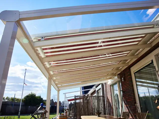 Gestreepte zonwering onder een glazen veranda-dak, geplaatst door VELZL