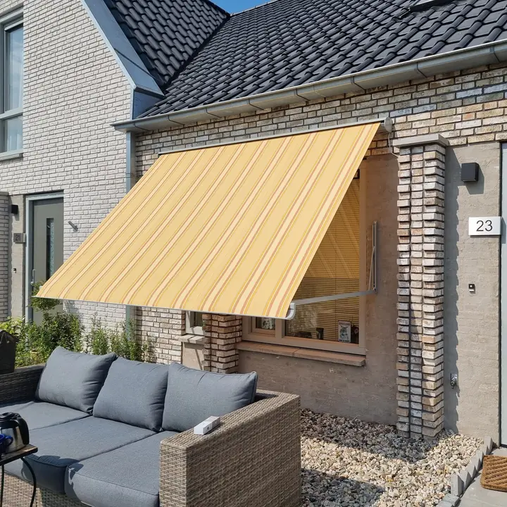 Gestreept uitvalscherm boven een raam naast de voordeur