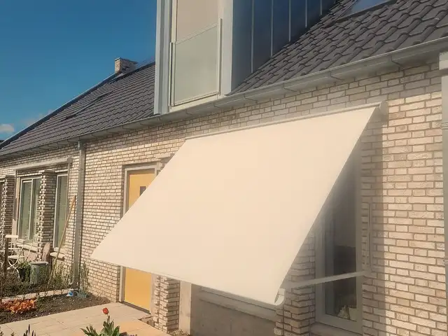 Crèmekleurig uitvalscherm aan een rijwoning, geplaatst door VELZL