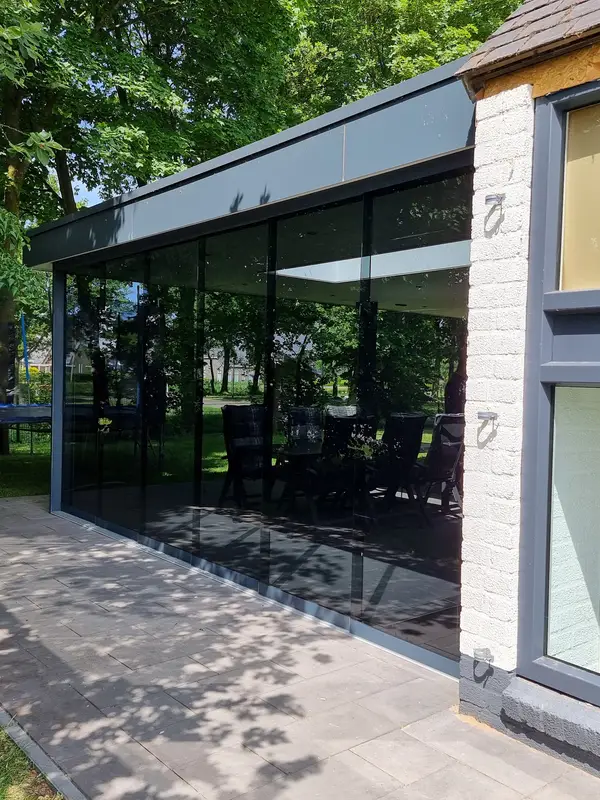 Glazen schuifwanden onder een bestaande houten overkapping