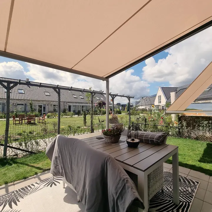 Pergola-zonwering van onderen gezien, met uitzicht op de tuin