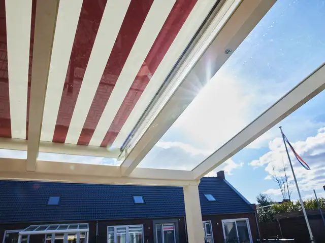 Rood-witte zonwering onder een glazen dak, geplaatst door VELZL