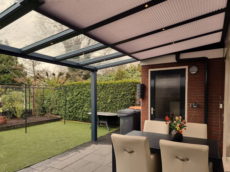 Verandazonwering boven een glazen verandadak, van onderen gezien